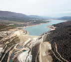 Vista a&eacute;rea del embalse de Yesa. A la izquierda de la presa y de las obras del recrecimiento, la ladera que recientemente se ha deslizado y las casas desalojadas.