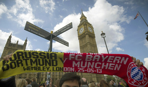 Un aficionado, con una bufanda conmemorativa de la final de Champions, junto al Big Ben londinense.