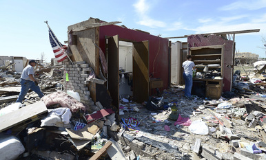 Dos personas rescatan sus pertenencias de entre los escombros en Moore.