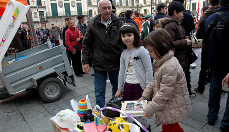 Dos niñas depositan sus juguetes en el punto de recogida de la plaza de los Fueros.. carasuán