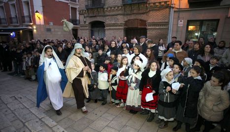 María y José pasan por la plaza Vieja de Tudela rodeados de niños participantes en el belén viviente y el público asistente.. NURA G.LANDA