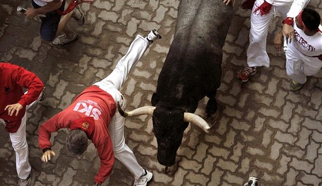 Un toro, rozando a un corredor en la bajada del callejón. EFE. .