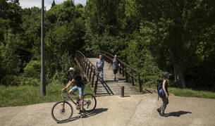 Varias personas disfrutan del buen tiempo en Huarte.