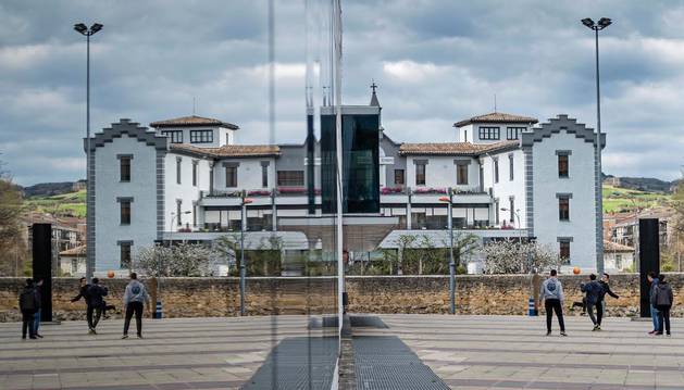 Imagen de la fachada acristalada del polideportivo, en la que se refleja la residencia San Jerónimo.