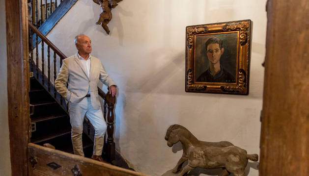 Jesús Montes en la escalera de Karakoetxea, ante el retrato que le hizo Menchu Gal cuando tenía 18 años y unos caballos etruscos.