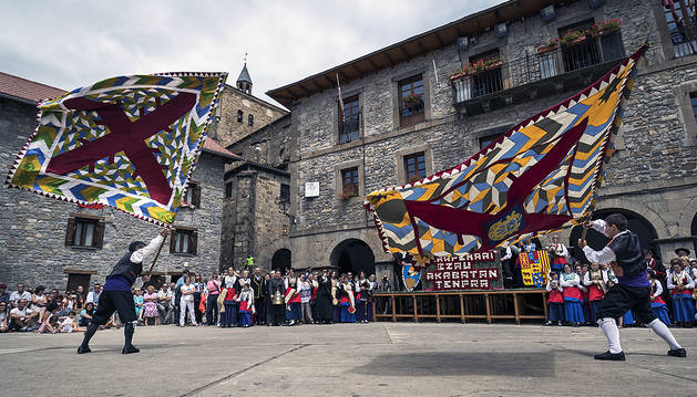 Julio Beretens Tapia (izda.) con la bandera de Isaba y Haritz Jamar Lusarreta (dcha.) con la del Roncal bailando en la plaza de la Constitución.