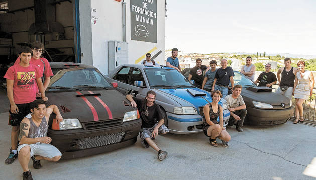 Imagen de los alumnos que han completado el curso del Servicio Navarro de Empleo con los coches que han construido.