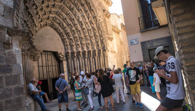 Varias personas admiran y fotografían la Puerta del Juicio de la Catedral de Tudela, antes de una visita guiada a la misma.