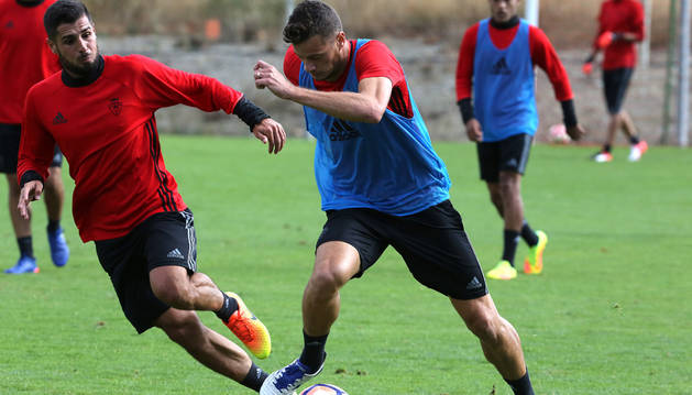 Oriol Riera conduce el balón en presencia de Fran Mérida durante un entrenamiento en Tajonar