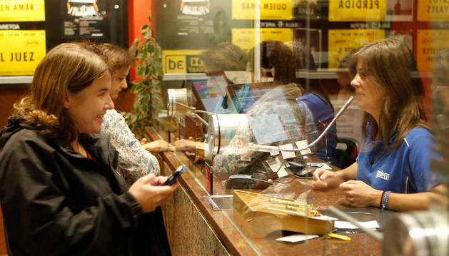 Foto de los espectadores compran sus entradas en la taquilla de los cines Golem Baiona de Pamplona.