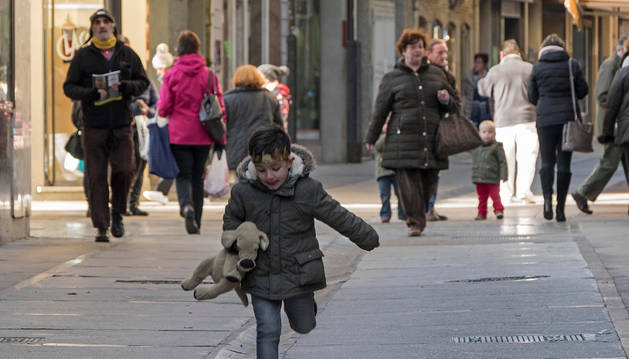 Imagen de un niño corre por la calle Mayor, muy transitada en la intersección con Baja Navarra.