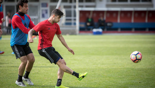 Sergio León golpea un balón ante la presión de Javier Flaño durante el entrenamiento de ayer.