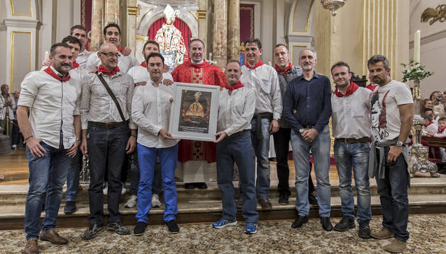 Agentes de Policía Foral y el párroco Javier Leoz, en la capilla de San Fermín con el retrato del santo regalo de la parroquia.