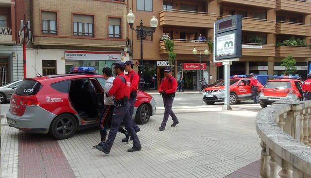 Agentes de Policía Foral llevan a uno de los detenidos al coche patrulla en el Paseo de Invierno de Tudela.