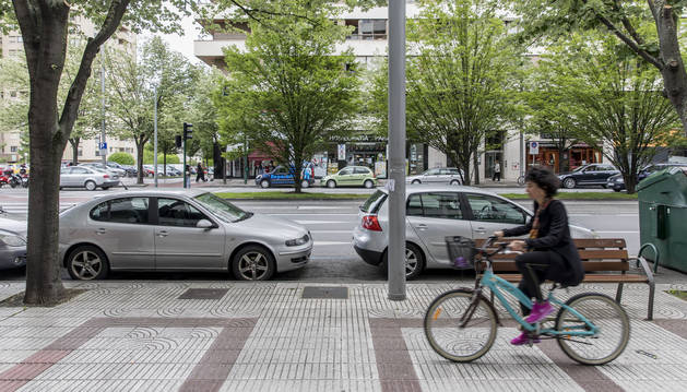 Una ciclista por la acera de Pío XII, junto al cordón de aparcamientos que se propone suprimir.