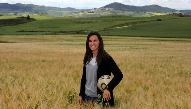 En medio de un campo de cereal en Biurrun, Eunate Arraiza Otazu, de 25 años de edad, sostiene un balón en un brazo.