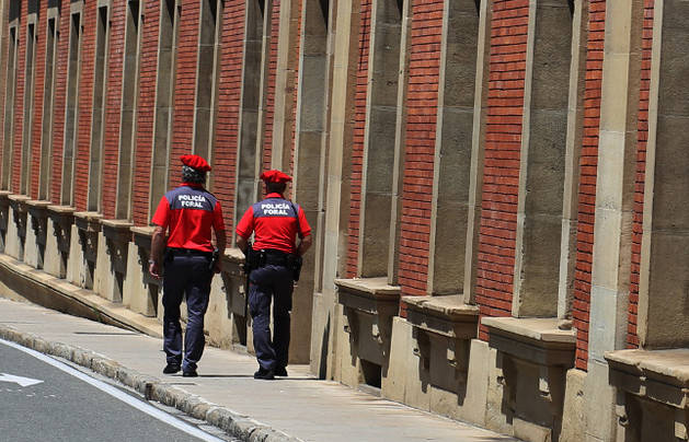 Dos agentes de la Policía Foral caminan junto al edificio del Parlamento de Navarra.