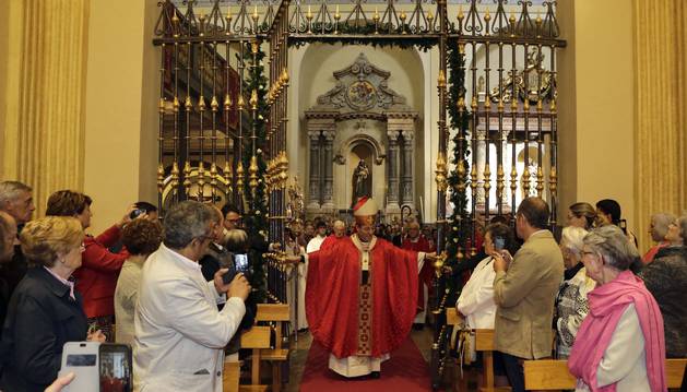 El arzobispo Francisco Pérez abre la verja que da acceso a la capilla de San Fermín.