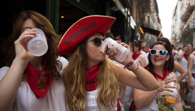 Dos mujeres, con el vaso reutilizable impulsado por el Ayuntamiento, después del Chupinazo de 2017.