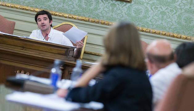 El alcalde Eneko Larrarte, al fondo, muestra unos papeles a concejales de UPN y PP, de espaldas.