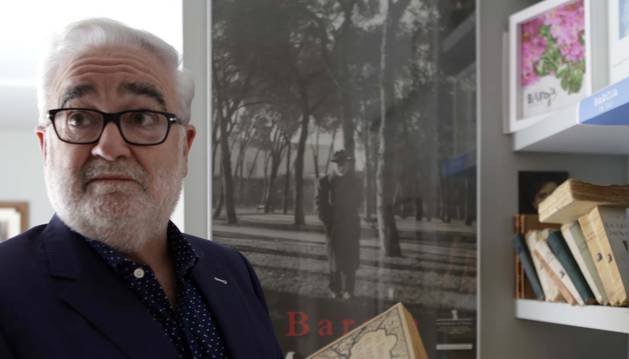 Joaquín Ciáurriz ojea las primeras ediciones de libros de Baroja de su colección. Detrás, la célebre foto del novelista paseando por el Retiro.