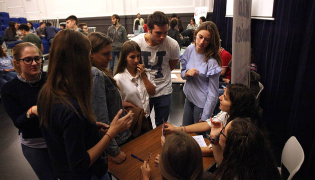Varios alumnos piden información a representantes de una de las asociaciones participantes en la feria.