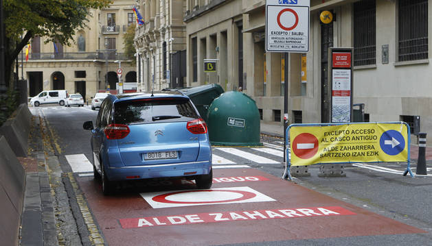 Un vehículo circula por el paseo de Sarasate. Tres señales, una pintada y dos verticales, indican la restricción de tráfico.