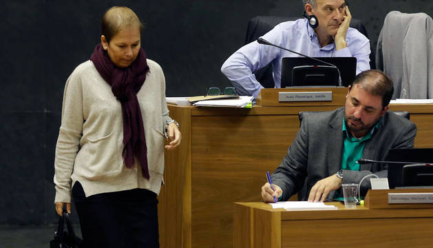 La presidenta Uxue Barkos se dirige a su escaño. Sentados, Adolfo Araiz (EH Bildu) y, tomando notas, Unai Hualde (Geroa Bai).