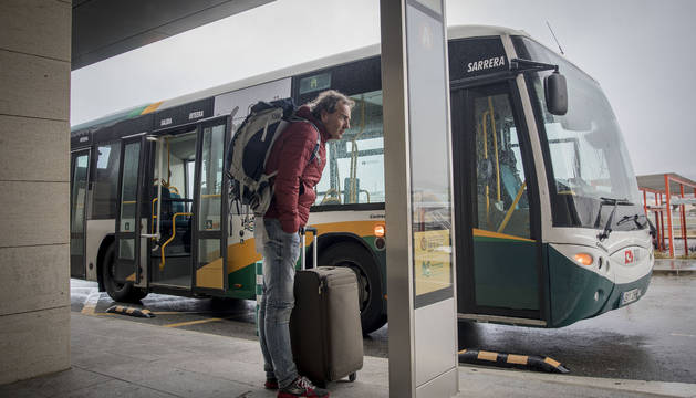 Un viajero consulta el cartel informativo del transporte urbano comarcal, anteayer, en el aeropuerto de Noáin.