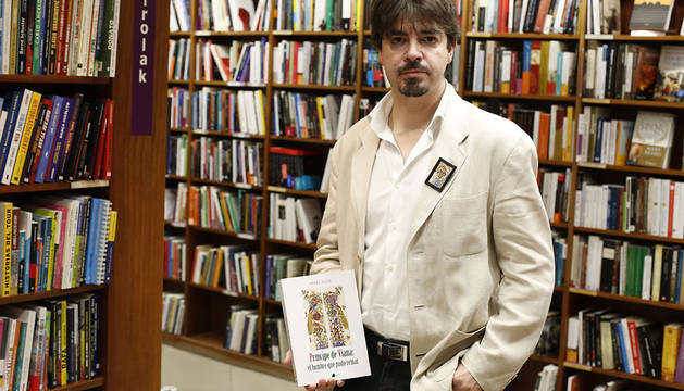 Mikel Zuza, posando ayer en la librería Elkar Comedias con un ejemplar de su libro, Príncipe de Viana: el hombre que pudo reinar.