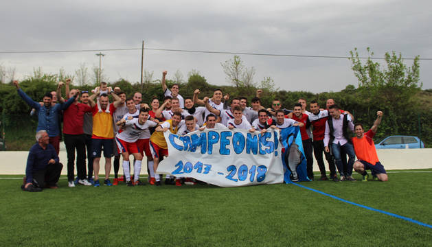 Plantilla y técnicos de la Mutilvera celebrando ayer su primer título en Tercera, después del partido contra el Idoya, en Iturtxipia (Oteiza).