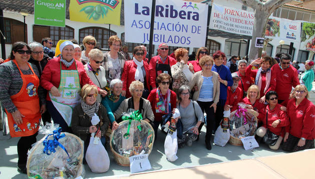 Los tres premiados en el concurso posan junto a los jamones y las cestas que obtuvieron como galardón.