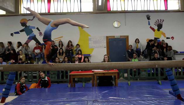 Equilibrio, fuerza, elasticidad y técnicas, claves para poder realizar un ejercicio como el que afrontaba la gimnasta en la barra ante la mirada de público y otras competidoras.