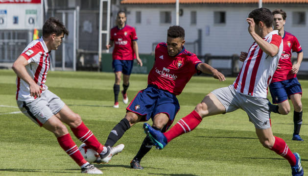 Antonio Otegui busca sacar la pelota ante dos rivales del Bilbao Athletic