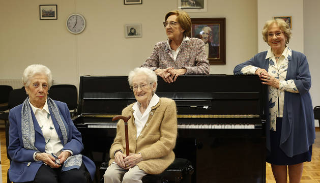 En primer plano (izq.-dcha.), María Eva Zabalza, Conchita Goñi y Chonin Asurmendi, posando juntas en la sala de ensayos de la Coral de Cámara de Pamplona. Detrás del piano, Mari Chari Morondo, hija de Luis Morondo (a sus espaldas, un retrato del fundador y primer director de la Coral).