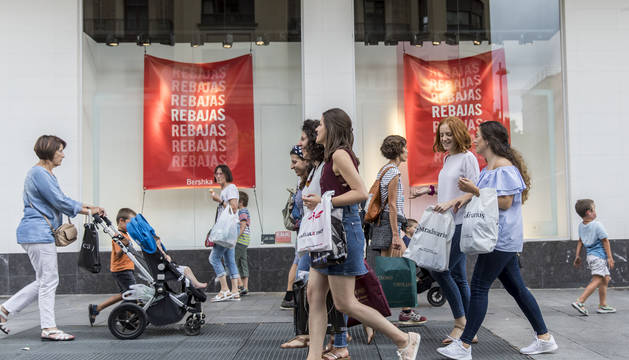 Grupos de amigas por la avenida de Carlos III de Pamplona, con las bolsas de la compra en rebajas.