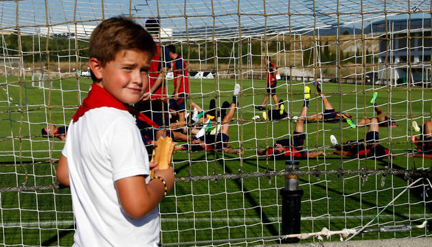 Un joven aficionado rojillo presencia uno de los primeros entrenamientos de Osasuna la pasada temporada, el que tuvo lugar el 11 de julio en plenas fiestas de San Fermín.