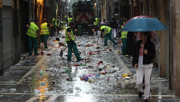 foto de Los servicios de limpieza recogen la basura y los vasos de plástico tras una noche de fiesta.