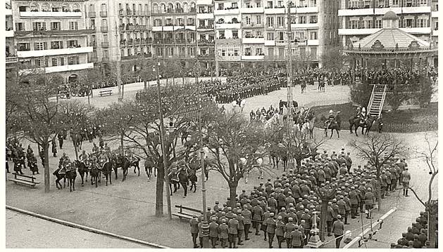 23 DE MARZO DE 1924. Vista de la mitad de la plaza del Castillo, entonces oficialmente de la Constitución, con distintas unidades militares, formadas para asistir al acto de la jura de bandera de los nuevos reclutas. Se aprecia el antiguo kiosco para los conciertos de las bandas de música, que en 1943 fue sustituido por el actual.
