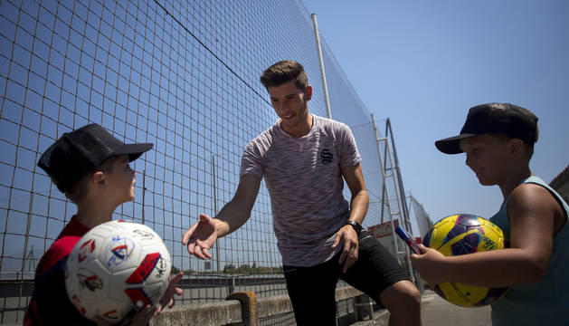Dos jóvenes aficionados rojillos se acercan a David García en Tajonar para que les firme el balón.