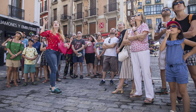 Varias personas escuchan atentamente las explicaciones de la guía encargada de realizar las visitas.