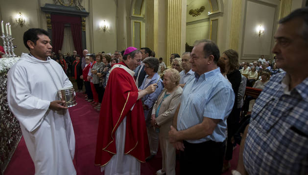 El arzobispo Francisco Pérez posa ayer el hisopo con agua bendita en la frente de una nueva cofrade de la Corte de San Fermín.