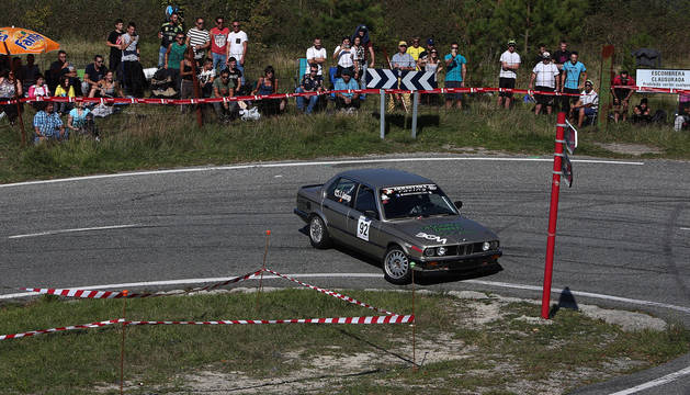 Un BMW, en la edición de 2017 de la Subida a Urbasa, tomando una curva ante la mirada de los aficionados.