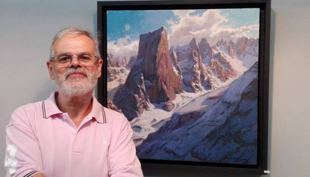 El artista Carlos Sempere posa ante uno de los cuadros de la exposición Viaje por los Picos de Europa.