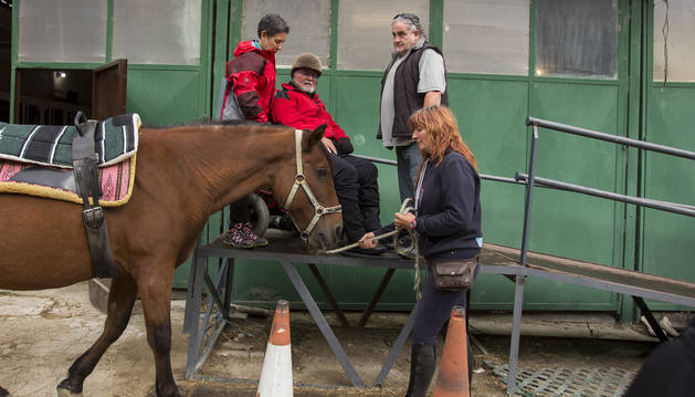 Koldo Manjón se dispone a subir al caballo, ayudado por su mujer. Biki Blasco sujeta al animal.