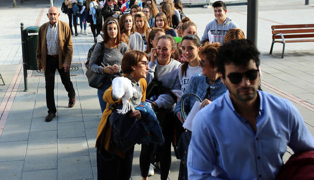 Fernando Lizaur, a la izquierda de la imagen, junto a la cola de personas que ayer aguardaba para presentar su solicitud.