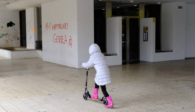 Una niña jugaba este lunes por la mañana con un patinete frente al portal del inmueble donde el sábado desalojaron a 73 estudiantes.