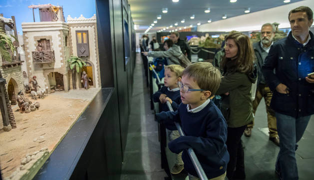 Unos niños miran con atención uno de los belenes que se pueden visitar en la sala del Baluarte.