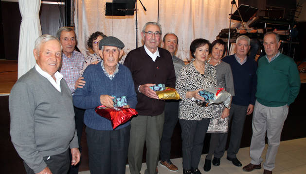 Los tres homenajeados mayores de 85 años, en el centro de la fotografía con sus obsequios.