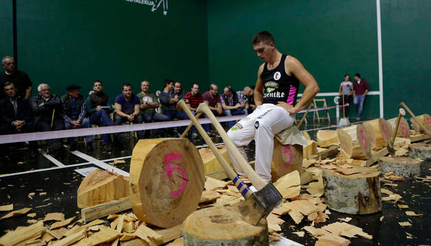 Iker Vicente, junto con todos los troncos que cortó en el último campeonato navarro de aizkolaris de primera que se disputó en el frontón de Santesteban.